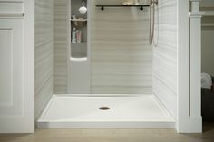 the shower door is open to reveal a white bathroom