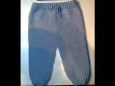 a blue knitted baby pants sitting on top of a table