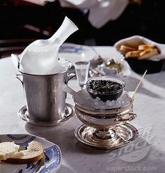 a table topped with plates and cups filled with food next to a silver tea pot