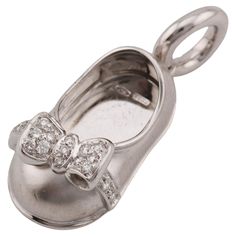 The Aaron Basha Diamond 18K White Gold Baby Girl Shoe Charm Pendant is a delightful piece of fine jewelry that captures the innocence and charm of infancy. Crafted from luxurious 18K white gold, this pendant features meticulous attention to detail, with a miniature baby girl shoe adorned with a delicate bow. The bow is adorned with sparkling diamonds, adding a touch of brilliance and elegance to the design. The pendant exudes a sense of whimsy and nostalgia, evoking memories of precious moments Silver Classic Jewelry For Baptism, Classic Silver Jewelry For Baptism, Elegant Round Jewelry For Baptism, Heirloom Diamond Jewelry With Intaglio, Engraved Elegant Jewelry For Baptism, Elegant Engraved Jewelry For Baptism, Elegant Hallmarked Jewelry For Baptism, Fine Jewelry Diamond Intaglio, Luxury Diamond Jewelry With Bow Detail