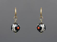 Elevate your look with our Stylish Dangle Drop Earrings with a Floral Pattern. These exquisite earrings feature large beads and a striking black and white ceramic design, making them a standout piece in any jewelry collection. Perfectly blending ethnic charm with modern elegance, they are ideal for any festive occasion. Whether you're dressing up for the holidays or adding a touch of sophistication to your everyday outfit, these earrings are the perfect accessory. 🔸 Material and Technique Handmade white clay beads, coated with glaze and original painting; tinted hematite; findings are 18k gold-plated brass. 🔸 Earrings size Total Length of Earring (Findings + Bead) - 4 cm (1.57 inch)  Bead Size - 1.8 cm (0.71 inch)  Total Weight (for Pair of Earrings) - 18g 🔸 Gift box  https://www.etsy.c Black Earrings With Large Round Beads, Traditional Black Earrings With Large Beads, Bohemian Black Earrings With Large Beads, Hematite Earrings, Brass Accessories, Large Beads, Ceramic Earrings, Keramik Design, Custom Painting