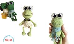 two crocheted frog dolls are being held by someone's hand