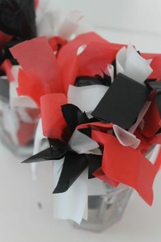 red, white and black paper flowers in a vase