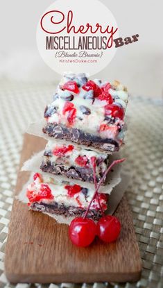 three dessert bars stacked on top of each other with cherries and white frosting