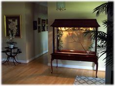 a living room filled with furniture and a large window covered in glass next to a wooden floor