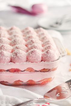 a dessert dish with powdered sugar and strawberries in it on a white table cloth