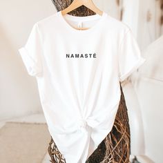 "By wearing this shirt, honor yourself and others with a NAMASTE greeting, expressing appreciation and respect. The meaning of the ancient Sanskrit word \"Namaste\" is - \"I honor the place in you in which the whole universe resides. I honor the place of love, light, and peace. We are one when you are in that place in you, and I am in that place in me.\" P.s. You may also like this design - https://www.etsy.com/listing/1327657465/namaste-unisex-organic-t-shirt-yoga?ref=listings_manager_grid USEFUL INFORMATION - This shirt is made just for you in a socially and environmentally safe way. Honor our planet a little bit by reducing your footprint with this eco-friendly Bella Canvas T-shirt!  - The printing process is eco-friendly, and the inks are water-based, biodegradable, and non-toxic. - De Conscious White Crew Neck Top, White Conscious Crew Neck Top, Relaxed Fit Yoga T-shirt With Letter Print, White Crew Neck Top For Meditation, White Crew Neck Top, Inspirational White T-shirt For Gift, Inspirational White T-shirt As Gift, Relaxed Fit T-shirt With Letter Print For Yoga, Relaxed Fit Letter Print T-shirt For Yoga