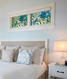 a bedroom with two stained glass windows above the bed and nightstands on either side