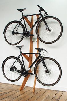 two bikes are mounted to a wooden stand