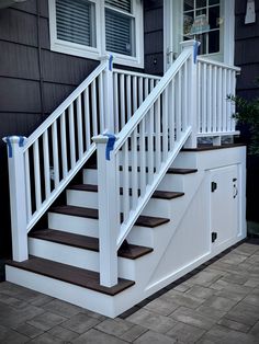 a set of stairs leading up to the front door of a house with white railings