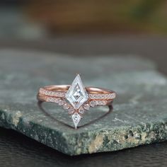 a close up of a diamond ring on a rock