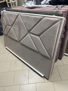 a bed frame that is laying on the floor next to other furniture and mattresses