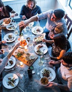 a group of people sitting around a table eating food