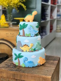 a three tiered cake with dinosaurs on it