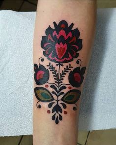 a woman's leg with a tattoo on it that has flowers and hearts in the center