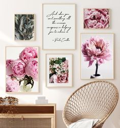 pink flowers are hanging on the wall above a wicker chair