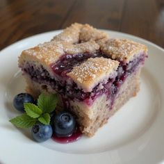 a piece of cake on a plate with blueberries