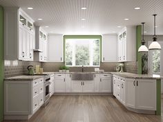 a large kitchen with white cabinets and green trim on the walls is shown in this image