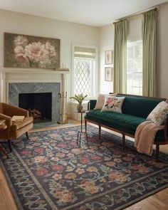 a living room filled with furniture and a rug on top of a hard wood floor