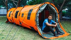 a man is sitting in an orange tent