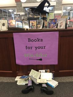 a purple sign that says books for your witch toes on the floor in front of a pile of books