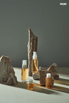 three bottles and two rocks are shown in front of a gray background with the words mam on it