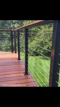 a wooden deck with metal railing and handrails