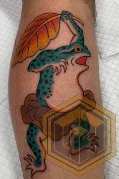 a frog tattoo on the leg of a man