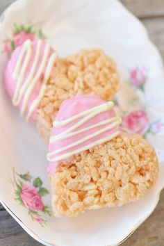 three desserts on a plate with pink and white icing, one is heart shaped