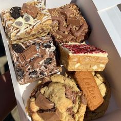 a box filled with lots of different types of cookies and desserts next to each other