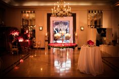 a room filled with tables covered in flowers and candles