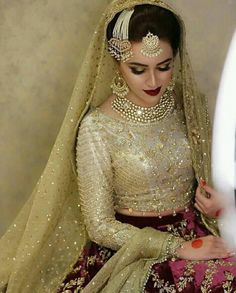 a woman wearing a bridal outfit and jewelry