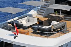 an aerial view of a yacht deck with lounge chairs and umbrellas on the deck