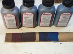 five bottles of paint sitting on top of a table