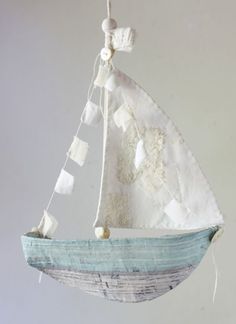 a small sailboat hanging from a string