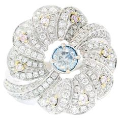 18kt white gold ring with diamonds Gold colour & karat: White gold 18kt Weight: 6.303 grams Set with- Stone type: Diamonds Shape: Round Carat: 0.25 ct Colour: Fancy Blue Clarity: SI Surrounding Stones: Diamonds 1) White Diamonds Carat weight: 0.869 ct (155 pcs) Color: F Clarity: VS1/VS2 Cut: Round 2) Pink Diamonds Carat weight: 0.074 ct (8 pcs) Colour: Fancy Pink Clarity: VS1/VS2 Cut: Round Report type and Number: AGL22080789 Formal Light Blue Diamond Ring, Luxury Blue Diamond Ring With Single Cut Diamonds, Luxury Blue Diamond Ring With Pave Setting, Luxury Light Blue Ring With Brilliant Cut, Luxury Light Blue Brilliant Cut Ring, Blue Diamond Ring With Single Cut Diamonds, Blue Diamond Ring With Pave Setting In Platinum, Blue Diamond Rings With Single Cut Diamonds, White Topaz Ring With Brilliant Cut In Luxury Style