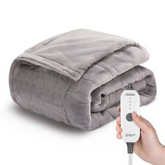 a person is holding a remote control in front of a blanket on a white background