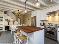 a kitchen with white cabinets and an island in front of the stove top oven is shown