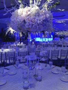 the centerpieces and tables are set up for an elegant wedding reception in blue lighting