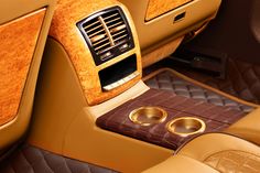 the interior of a luxury car with two gold rings on it's center console