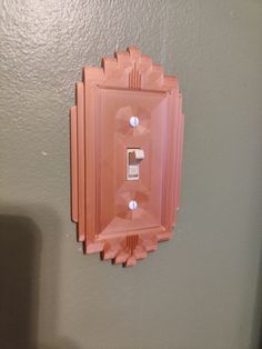 a pink light switch cover mounted to a wall