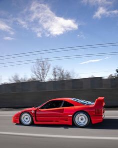 a red sports car driving down the road