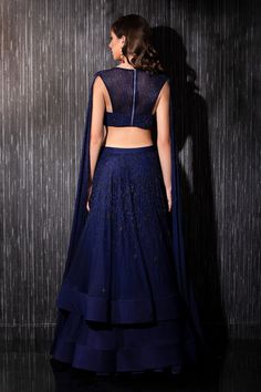 Navy net lehenga with glass beaded embroidery. Comes with a blouse with cape sleeves.
Component: 2
Pattern: Embroidered
Type Of Work: Glass beads
Neckline: Round
Sleeve Type: Cape Sleeves
Fabric: Net
Color: Blue
Other Details: 
Heavily embroidered blouse
Closure : Back zip
Occasion: Wedding - Aza Fashions Blouse With Cape, Net Lehenga, Beaded Neckline, Cape Sleeves, Embroidered Blouse, Set For Women, Aza Fashion, Beaded Embroidery, Blue Glass