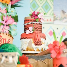 there is a multi layer cake with flowers on the top and other decorations around it