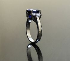 Dekara Designs Collection Metal- 90% Platinum, 10% Iridium. Stones- 1 Natural Untreated 3.88 Carat Oval Cut Ceylon Blue Sapphire. 2 Moon Cut Diamonds, F-G Color VS1 Clarity 0.77 total carats This ring is a size 6, but could be sized up or down a few sizes. This ring could be made in your specific size within 5-10 business days. Could take a little more time due to the ceylon sapphire being a rare stone. The sapphire may be a bit smaller or bigger. We can make the same design in a smaller or bigg Formal Blue Sapphire Ring Gia Certified, Modern Blue Asscher Cut Rings, Modern Blue Sapphire Ring, Modern Sapphire Rings Gia Certified, Gia Certified Blue Topaz Round Cut Ring, Gia Certified Blue Topaz Ring With Round Cut, Modern Blue Sapphire Ring For Formal Occasions, Blue Sapphire Ring With Asscher Cut And Accent Stones, Blue Tanzanite Ring With Trillion Cut