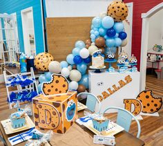 a room filled with blue and white balloons, cake boxes, and other items on the floor