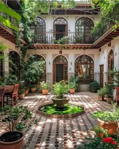 an outdoor courtyard with potted plants and chairs