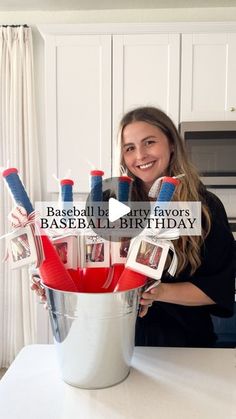 a woman holding a bucket full of red, white and blue toothbrushes