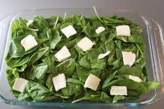 spinach and cheese in a glass dish on a table