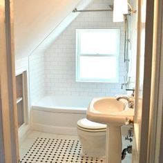 an attic bathroom with black and white floor tiles